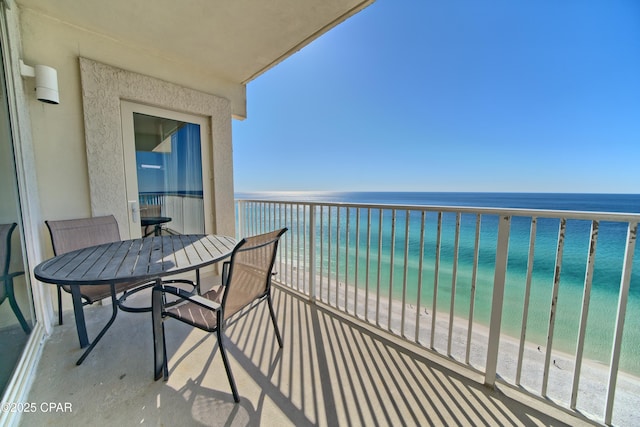 balcony featuring a view of the beach and a water view