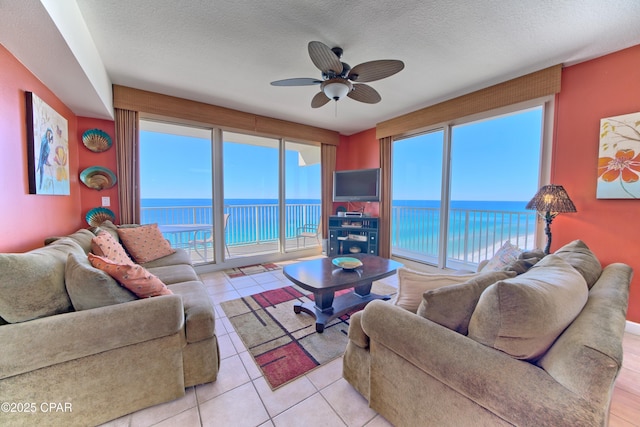 tiled living room with ceiling fan and a textured ceiling