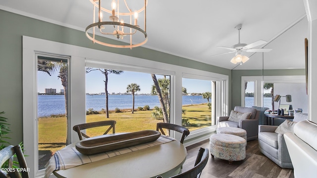 sunroom with a water view and ceiling fan with notable chandelier