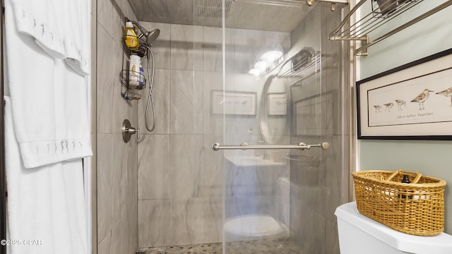 bathroom with an enclosed shower and toilet