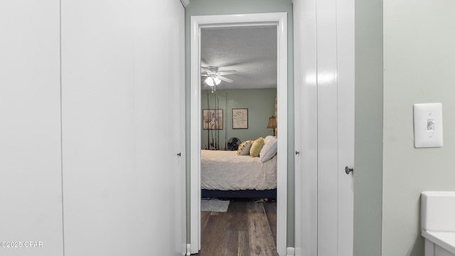 hall with hardwood / wood-style flooring and a textured ceiling