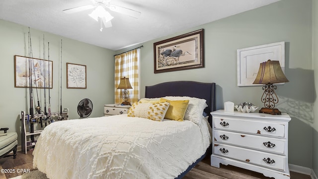 bedroom with dark wood-type flooring, ceiling fan, and a textured ceiling