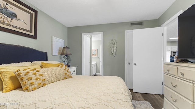 4271 Kingfish Ln Unit 271, Panama City Beach, FL 32408 - bedroom with visible vents, connected bathroom, and dark wood finished floors