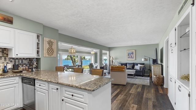 kitchen with white cabinetry, backsplash, stainless steel dishwasher, and kitchen peninsula