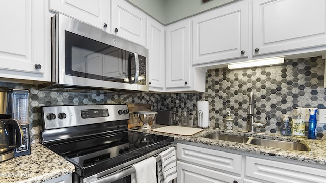 kitchen featuring white cabinets, appliances with stainless steel finishes, and backsplash