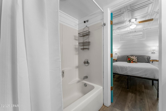 bathroom with wood walls, hardwood / wood-style floors, and shower / tub combo with curtain