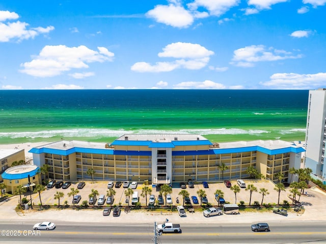 bird's eye view featuring a water view and a beach view