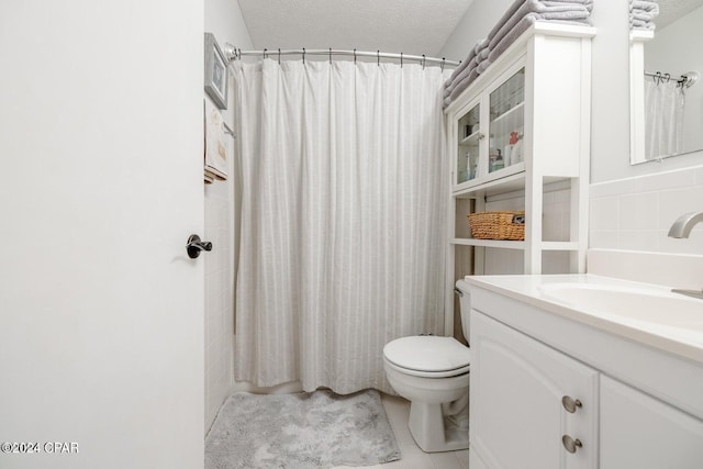 bathroom with a shower with shower curtain, tile patterned floors, vanity, a textured ceiling, and toilet