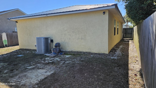 view of side of home with central air condition unit