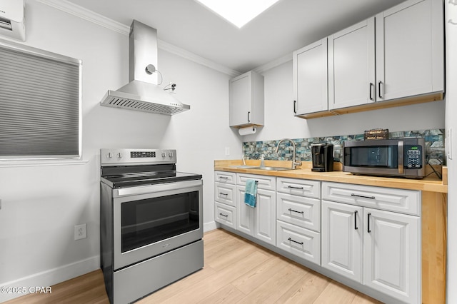 kitchen with appliances with stainless steel finishes, white cabinetry, a sink, and exhaust hood