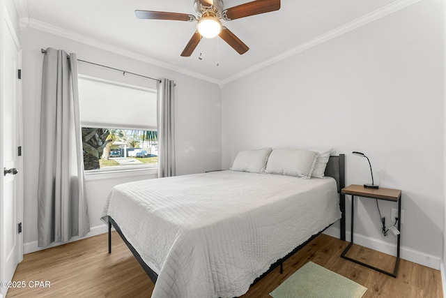 bedroom with ornamental molding, wood finished floors, a ceiling fan, and baseboards