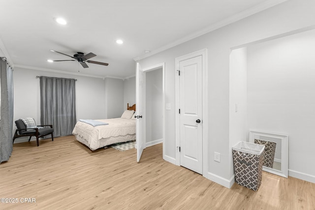 bedroom with light wood-style floors, baseboards, and crown molding