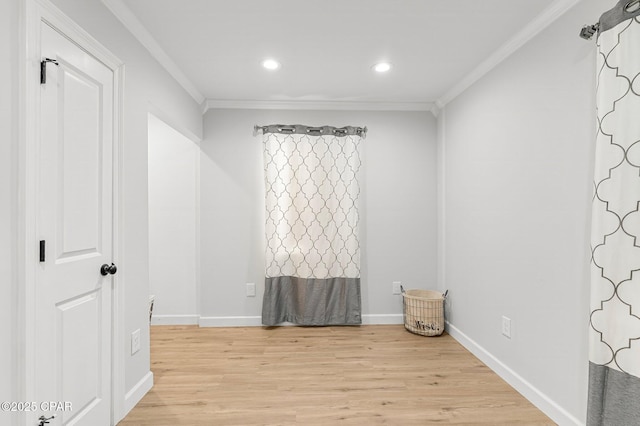 empty room featuring ornamental molding, light wood-type flooring, baseboards, and recessed lighting