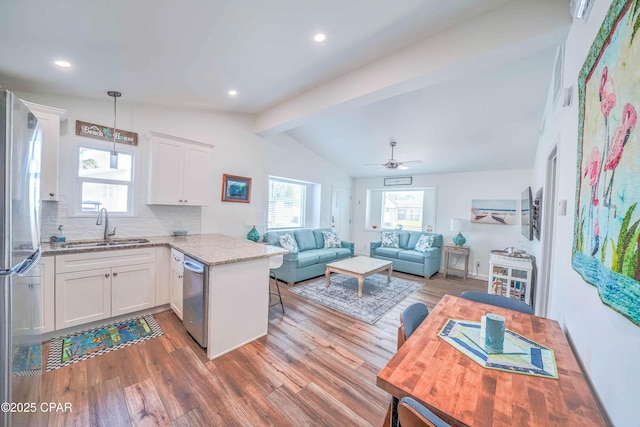 kitchen featuring white cabinetry, kitchen peninsula, sink, and stainless steel appliances