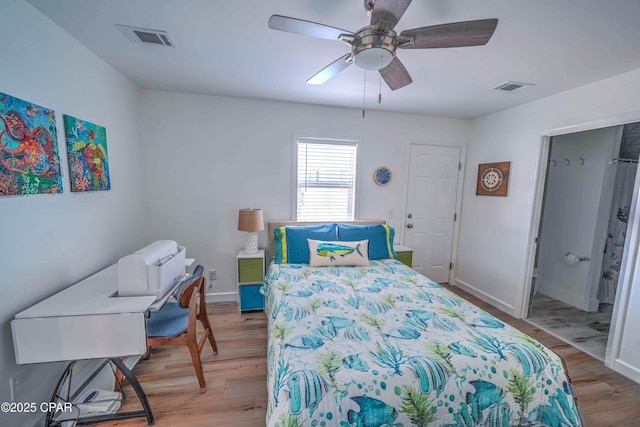 bedroom with ceiling fan, light wood-type flooring, and ensuite bath