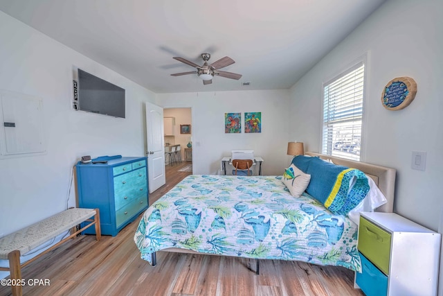 bedroom featuring electric panel, ceiling fan, and light hardwood / wood-style floors