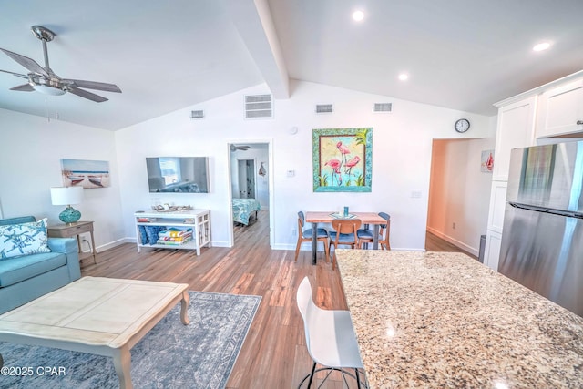 living room featuring vaulted ceiling with beams, ceiling fan, and light hardwood / wood-style floors