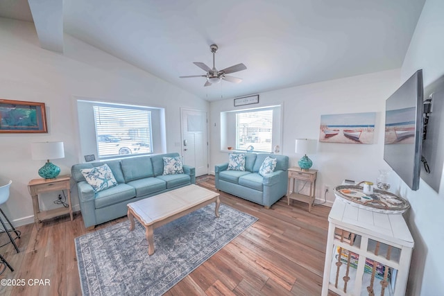 living room featuring ceiling fan, vaulted ceiling, and light hardwood / wood-style flooring