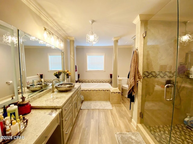 full bathroom with vanity, ornate columns, ornamental molding, hardwood / wood-style flooring, and separate shower and tub