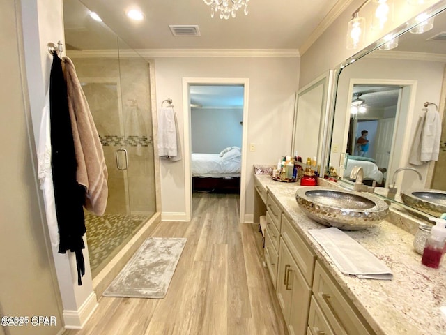 bathroom featuring vanity, ornamental molding, a shower with door, and wood-type flooring