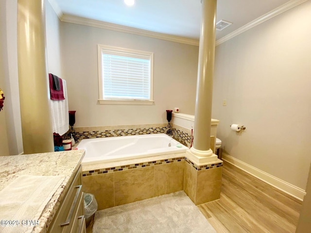 bathroom with decorative columns, a relaxing tiled tub, vanity, and ornamental molding