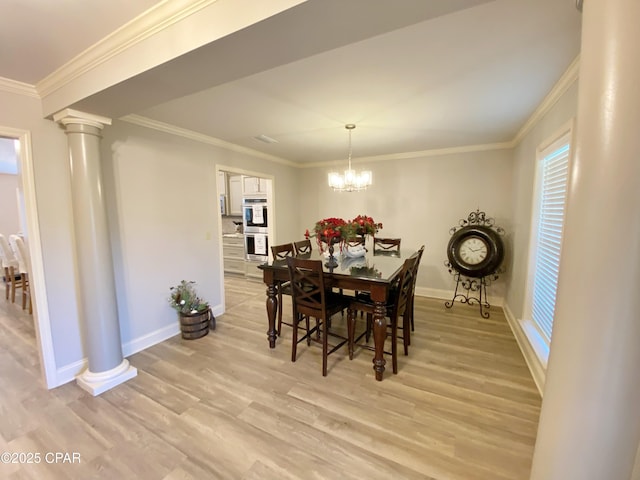 dining space featuring decorative columns, a chandelier, light hardwood / wood-style flooring, and ornamental molding