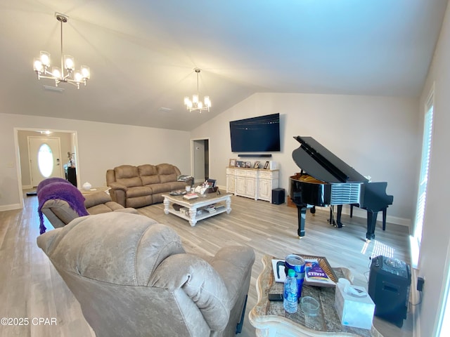 living room with wood-type flooring, a notable chandelier, and a healthy amount of sunlight