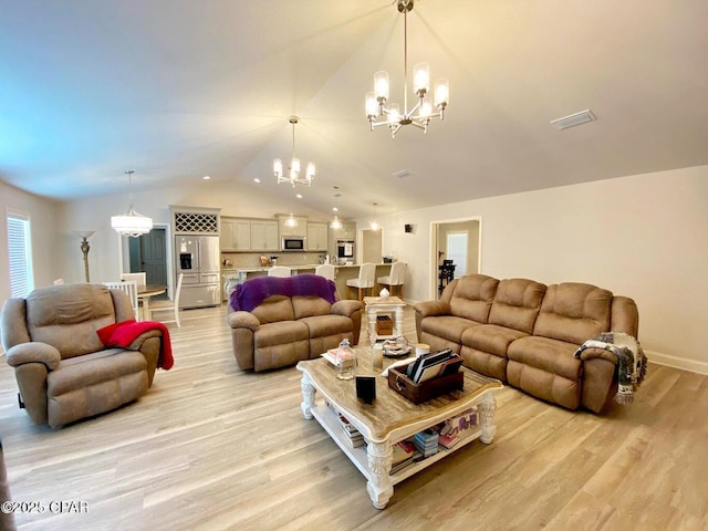 living room with light wood-type flooring, vaulted ceiling, and a notable chandelier