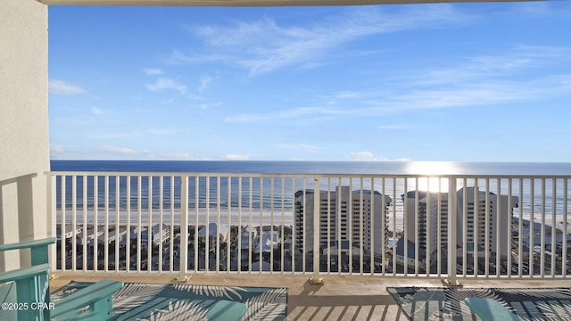 balcony featuring a view of the beach and a water view