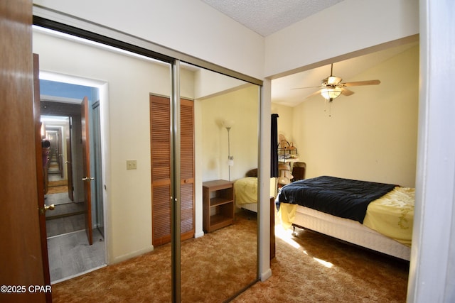 carpeted bedroom with a closet, a textured ceiling, and ceiling fan