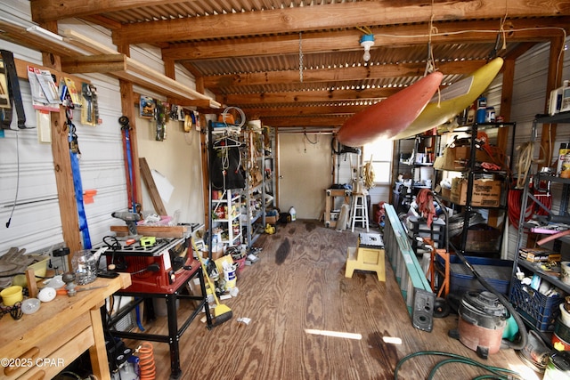 interior space with a workshop area, lofted ceiling with beams, and hardwood / wood-style flooring