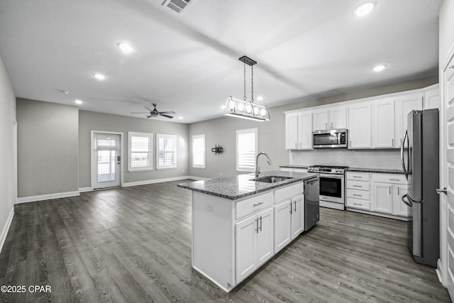 kitchen with appliances with stainless steel finishes, ceiling fan, sink, a center island with sink, and white cabinets