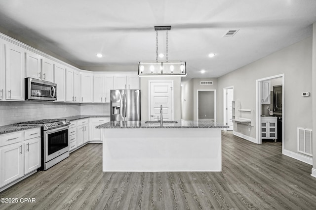 kitchen with white cabinetry, sink, an island with sink, decorative light fixtures, and appliances with stainless steel finishes