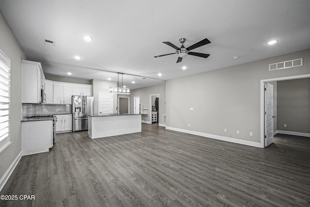 unfurnished living room with ceiling fan with notable chandelier, dark hardwood / wood-style flooring, and sink