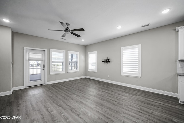 unfurnished living room featuring ceiling fan and dark hardwood / wood-style flooring