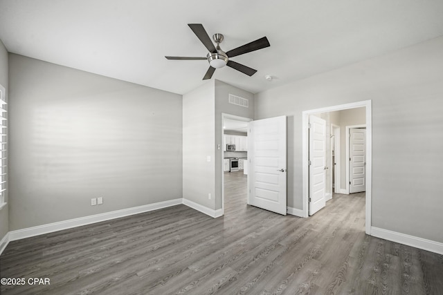 unfurnished bedroom with ceiling fan and dark hardwood / wood-style floors