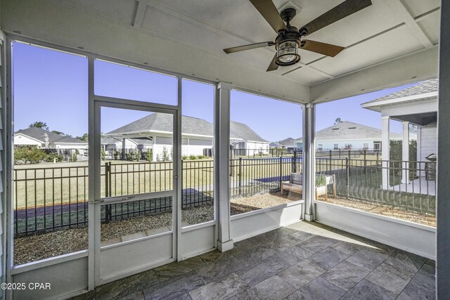 unfurnished sunroom with ceiling fan