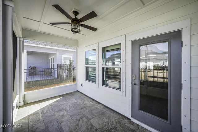 unfurnished sunroom featuring ceiling fan