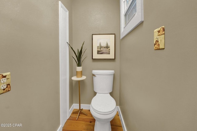 bathroom featuring wood-type flooring and toilet