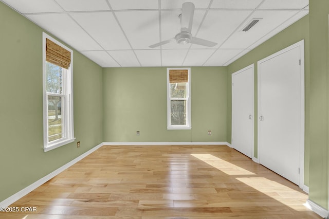 unfurnished bedroom with ceiling fan, a paneled ceiling, and light hardwood / wood-style flooring