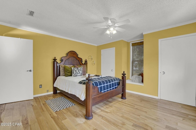 bedroom with ceiling fan, a textured ceiling, and hardwood / wood-style flooring