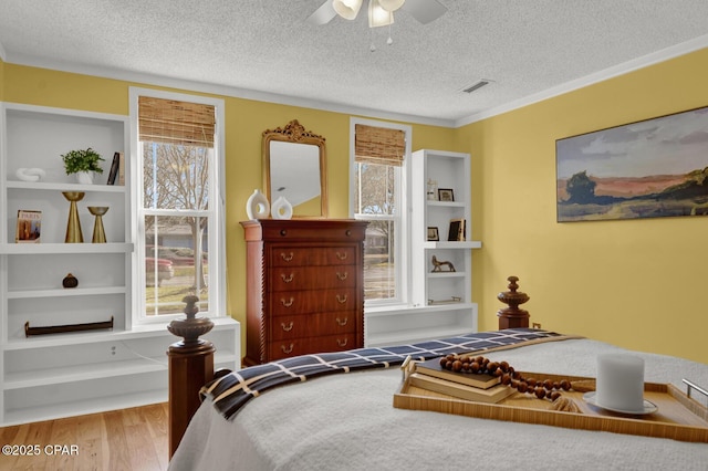 bedroom featuring ceiling fan, a textured ceiling, and light hardwood / wood-style flooring