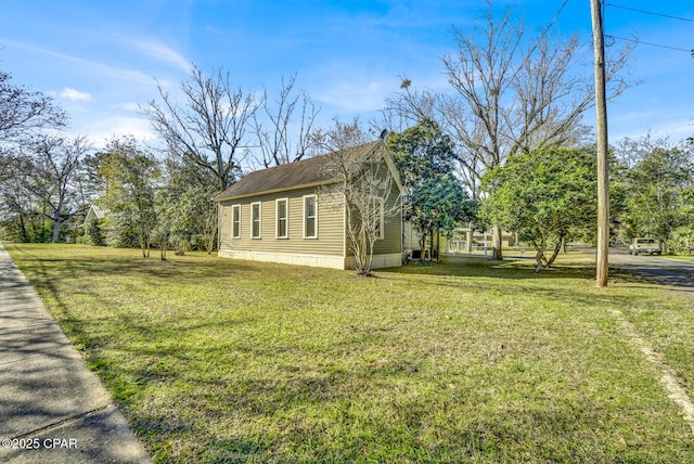 view of side of home with a yard