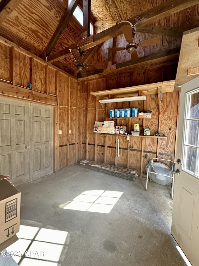 misc room with vaulted ceiling and wooden walls