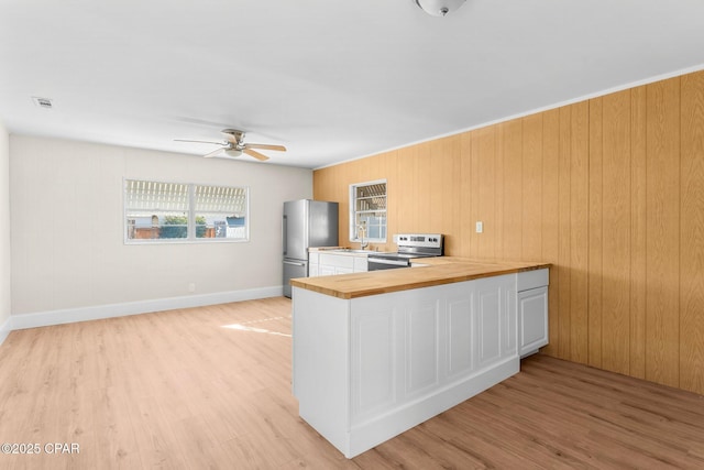 kitchen with ceiling fan, light wood-type flooring, kitchen peninsula, and appliances with stainless steel finishes