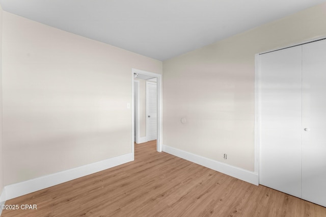 unfurnished bedroom featuring a closet and light wood-type flooring