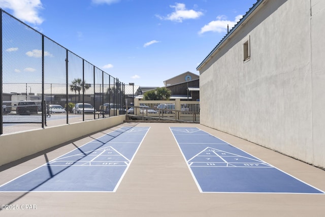 view of home's community featuring tennis court