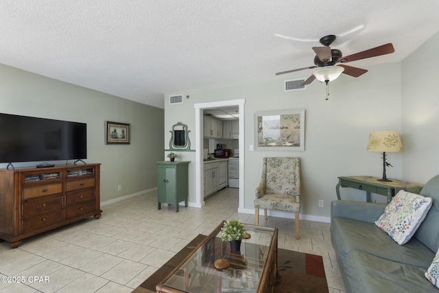 tiled living room featuring ceiling fan and a textured ceiling