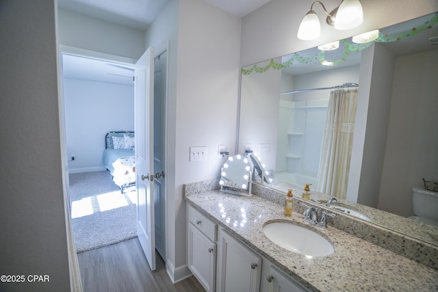 bathroom featuring wood-type flooring, vanity, and shower / bath combo