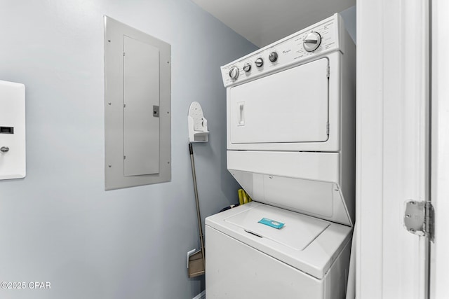 clothes washing area with electric panel, laundry area, and stacked washing maching and dryer